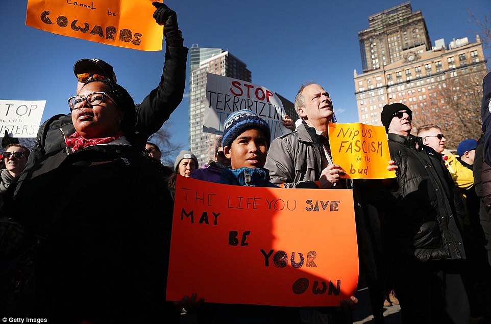 People of all ages are seen in New York's Battery Park, many carrying signs, during Sunday's demonstration 