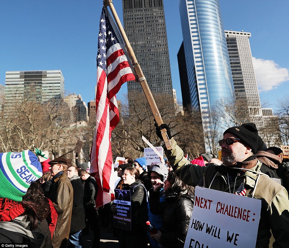 People attend an afternoon rally in Battery Park to protest President Donald Trump's 'Muslim ban' on Sunday afternoon