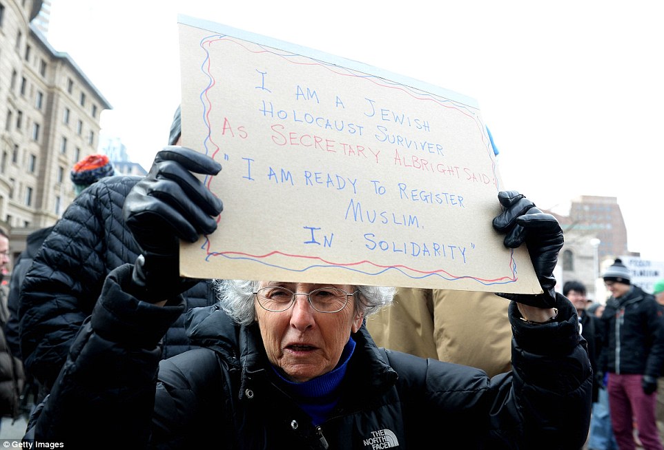 A woman who identified herself as a Jewish Holocaust survivor holds a sign saying she is willing to register as a Muslim in protest to Trump's ban