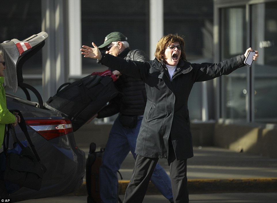 Expressing support: A woman dropping someone off for a flight waved back at demonstrators chanting across the road at Minneapolis-St Paul Airport