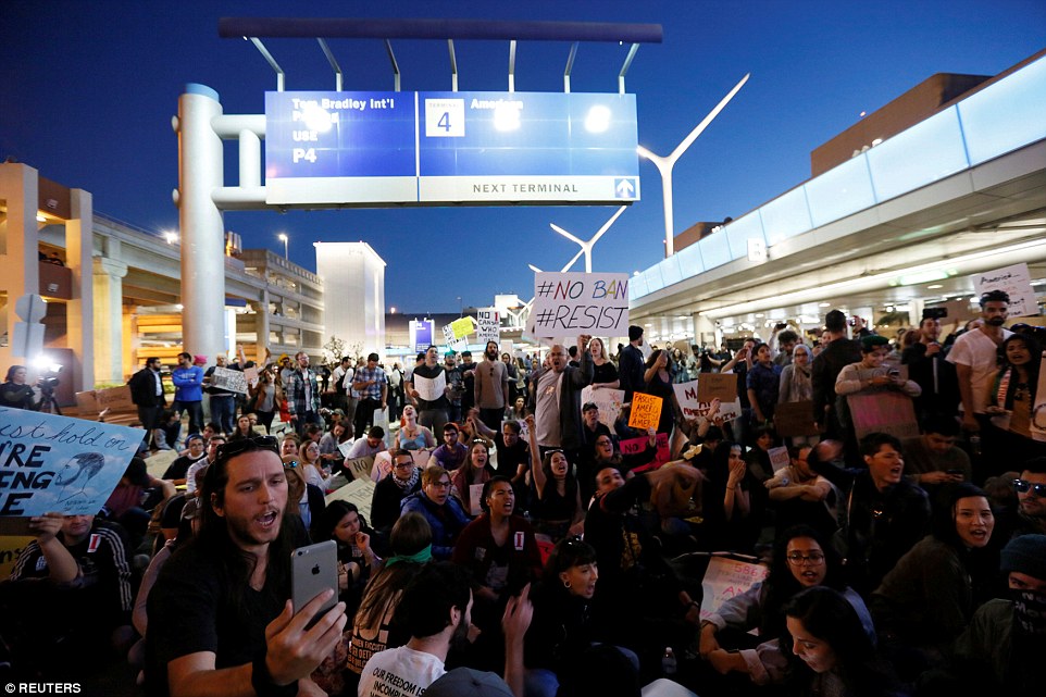 Protesters are pictured shutting down the lower level loop at LAX during a protest against the travel ban imposed by Trump