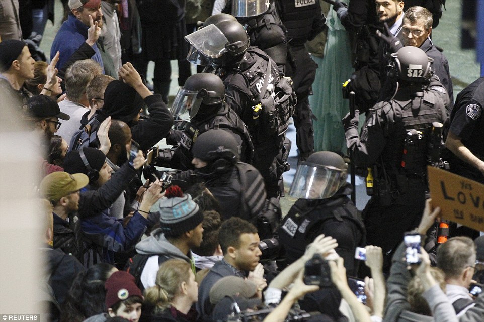 Riot police pushed activists gathered at Portland International Airport to protest against Trump's executive action travel ban