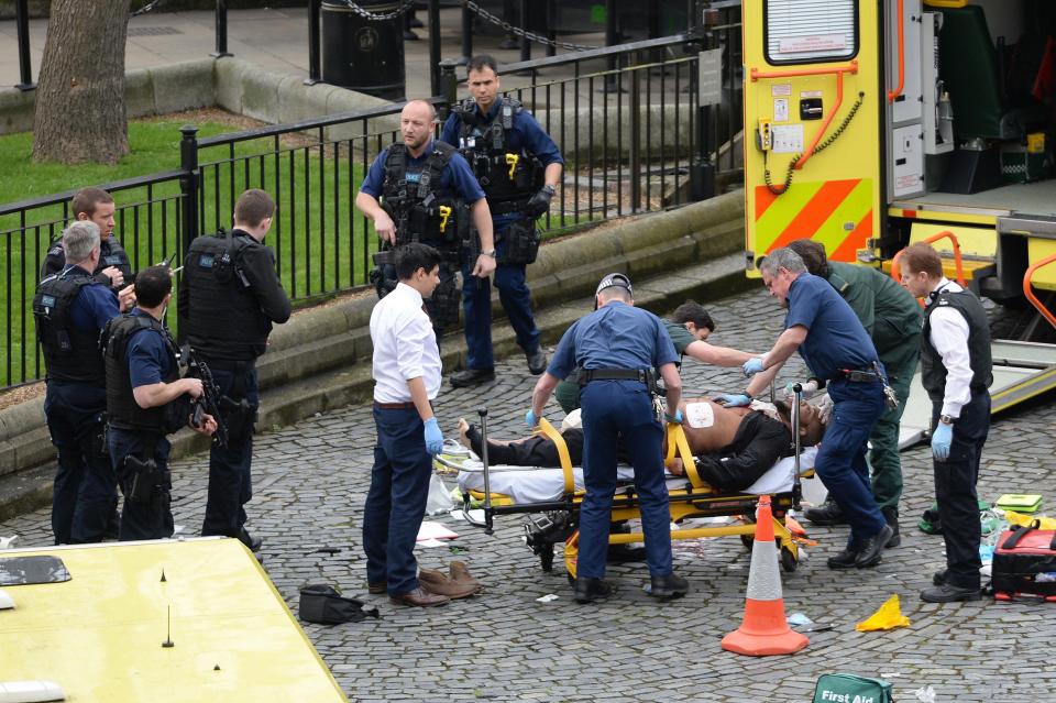 Paramedics treat a person, believed to be the suspect, at the scene as armed cops swarm the Parliament grounds