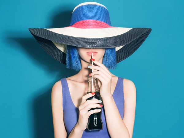 Girl With a Hat and a Blue Wig Drinking Soda