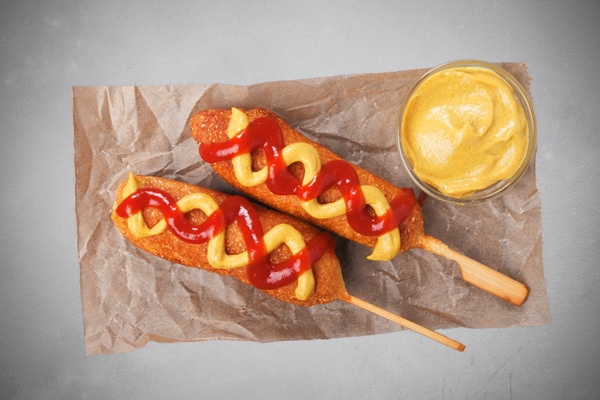 Two Corn Dogs With Ketchup and Mustard
